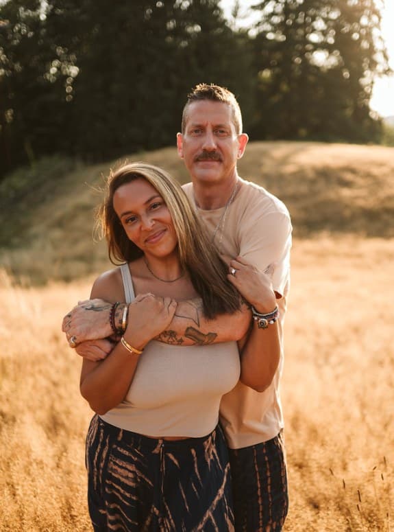 Benisha and Curt embracing in a golden field